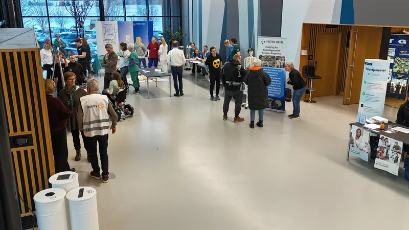 Stander i foajeen, blant annet fra Vestre Viken, med en Rotary-frivillig i hvit vest i forgrunnen